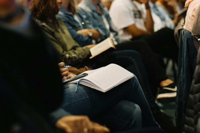 Eine Gruppe von Seminarteilnehmern folgt konzentriert dem Seminar.