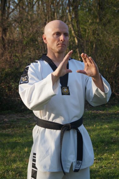 Kampfkunst: Fokushaltung Markus Koschorreck im Taekwondo-Anzug mit schwarzem Gürtel in fokussierter Grundhaltung.