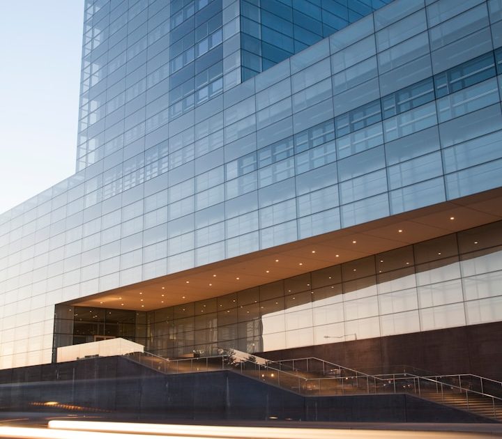 Hochhaus mit Glasfassade Moderne Glasfassade eines Hochhauses mit klaren Linien und sanften Beleuchtungseffekten.